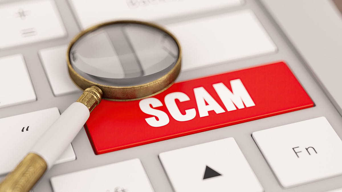 An image of scam written on a computer keyboard.
